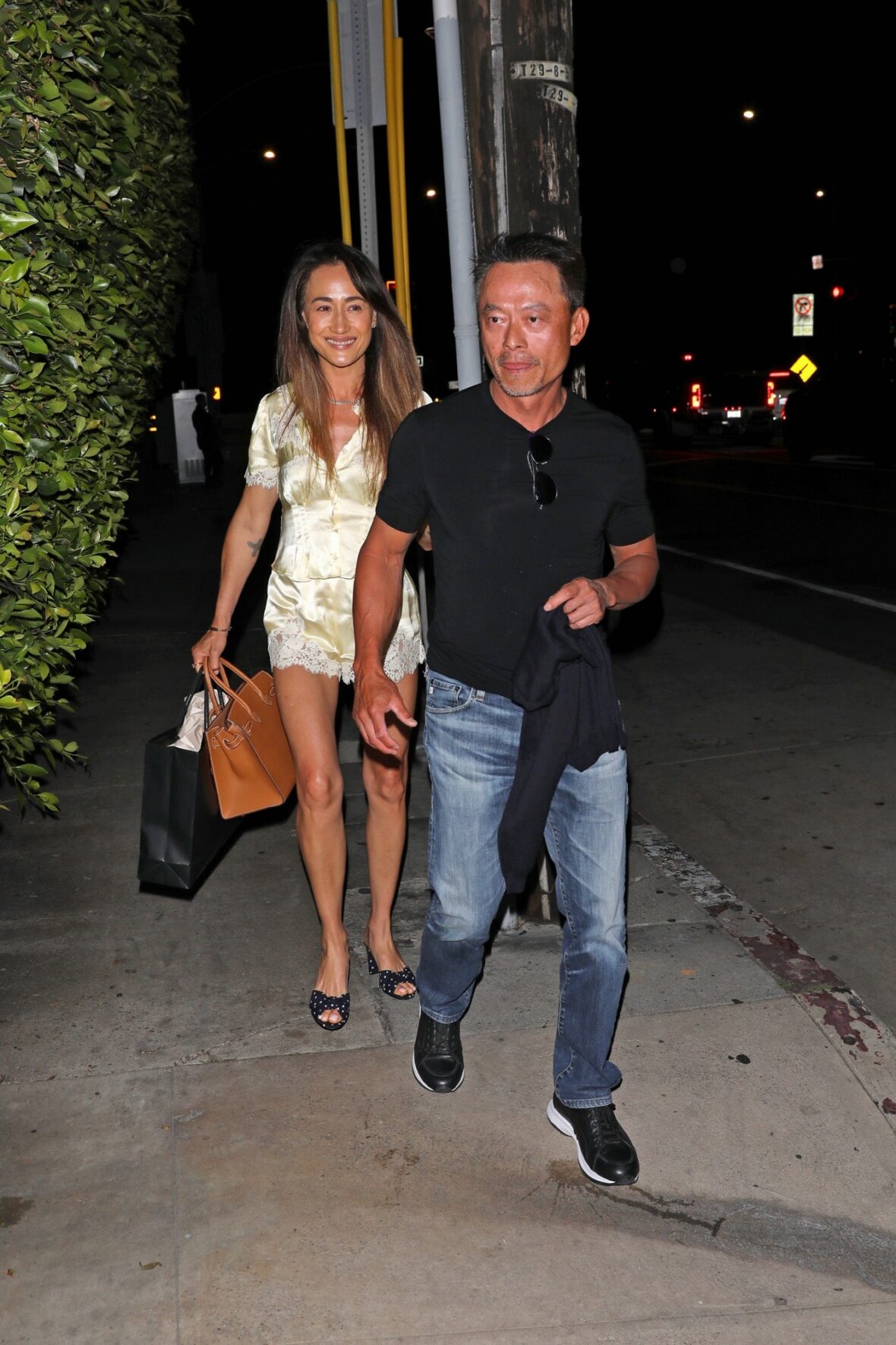 Maggie Q and Curtis Macnguyen hold hands 