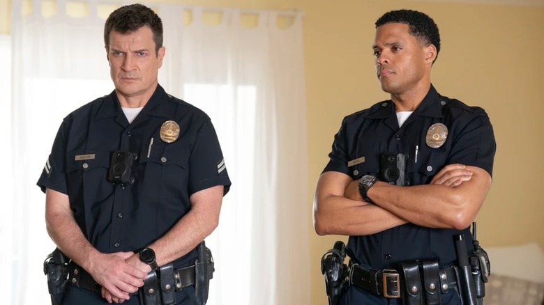 John Nolan and Miles Penn standing, looking serious