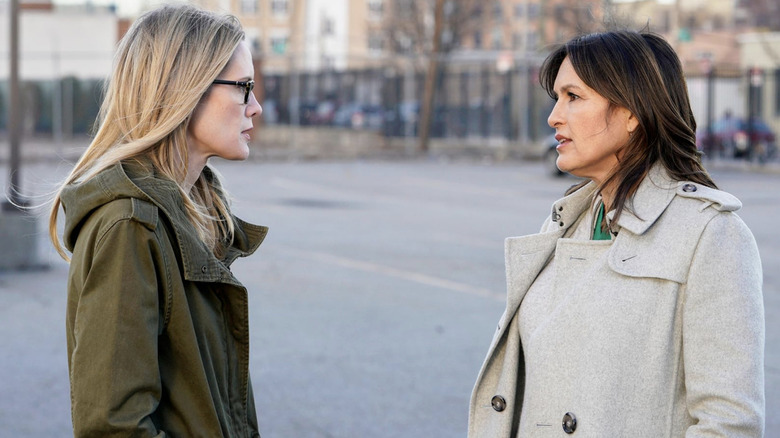 Alex Cabot in a green jacket and Olivia Benson in a white jacket facing each other in 