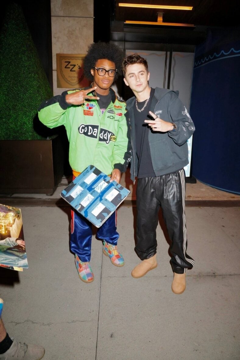 Timothee Chalamet poses for a fan outside