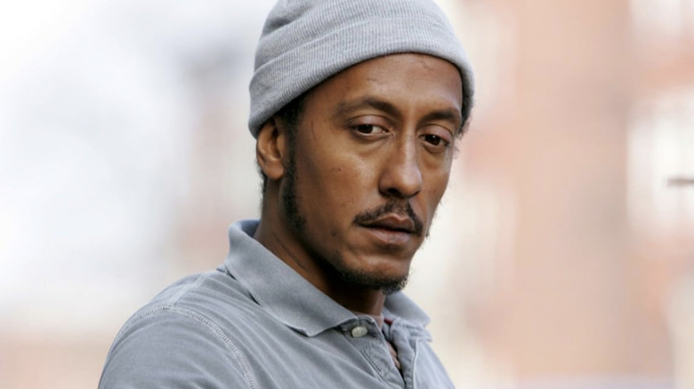 Bubbles wearing a grey shirt and a grey beanie in 