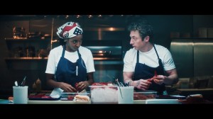 'The Bear' Season 5 stars Ayo Edebiri as Sydney Adamu and Jeremy Allen White as Carmen "Carmy" Berzatto, shown here standing in the kitchen, looking at each other, in the final season