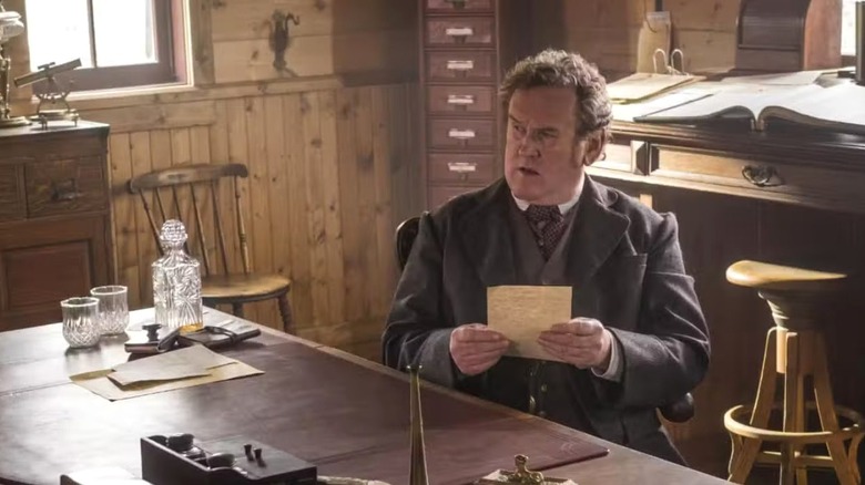 Doc Durant seated and reading a letter