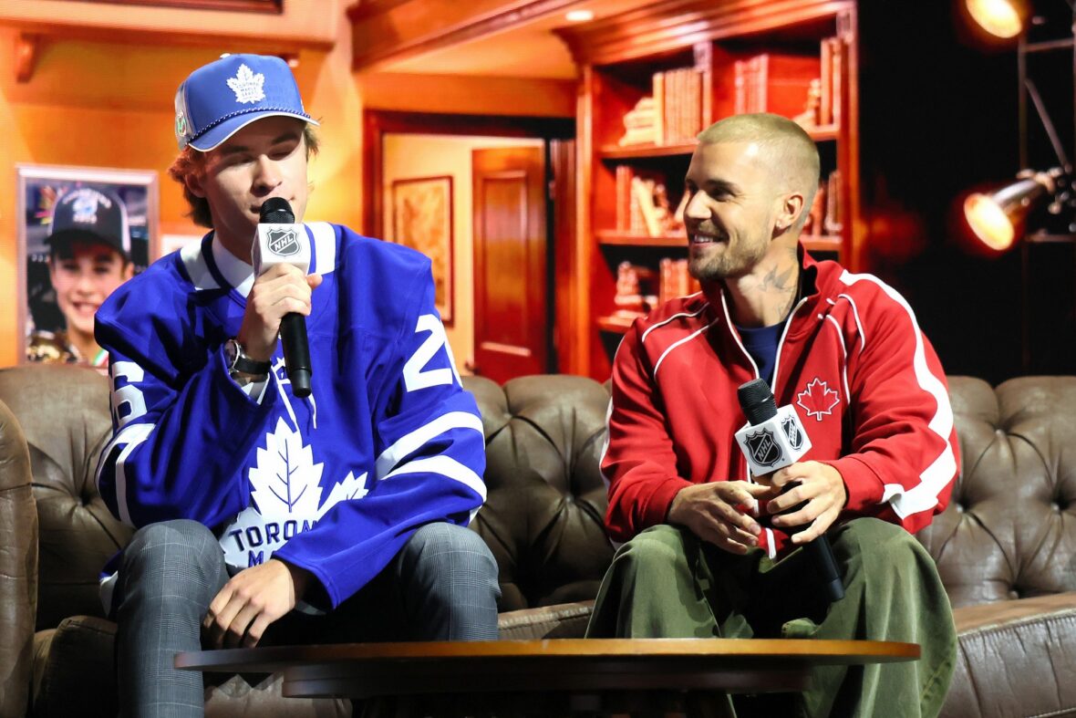Gavin McKenna of Canada and singer Justin Bieber look on after McKenna was drafted by the Toronto Maple Leafs