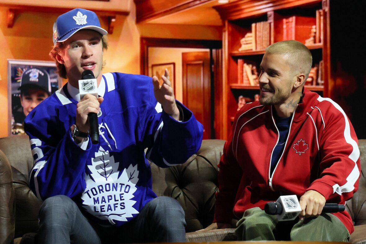 Gavin McKenna of Canada and singer Justin Bieber look on after McKenna was drafted by the Toronto Maple Leafs