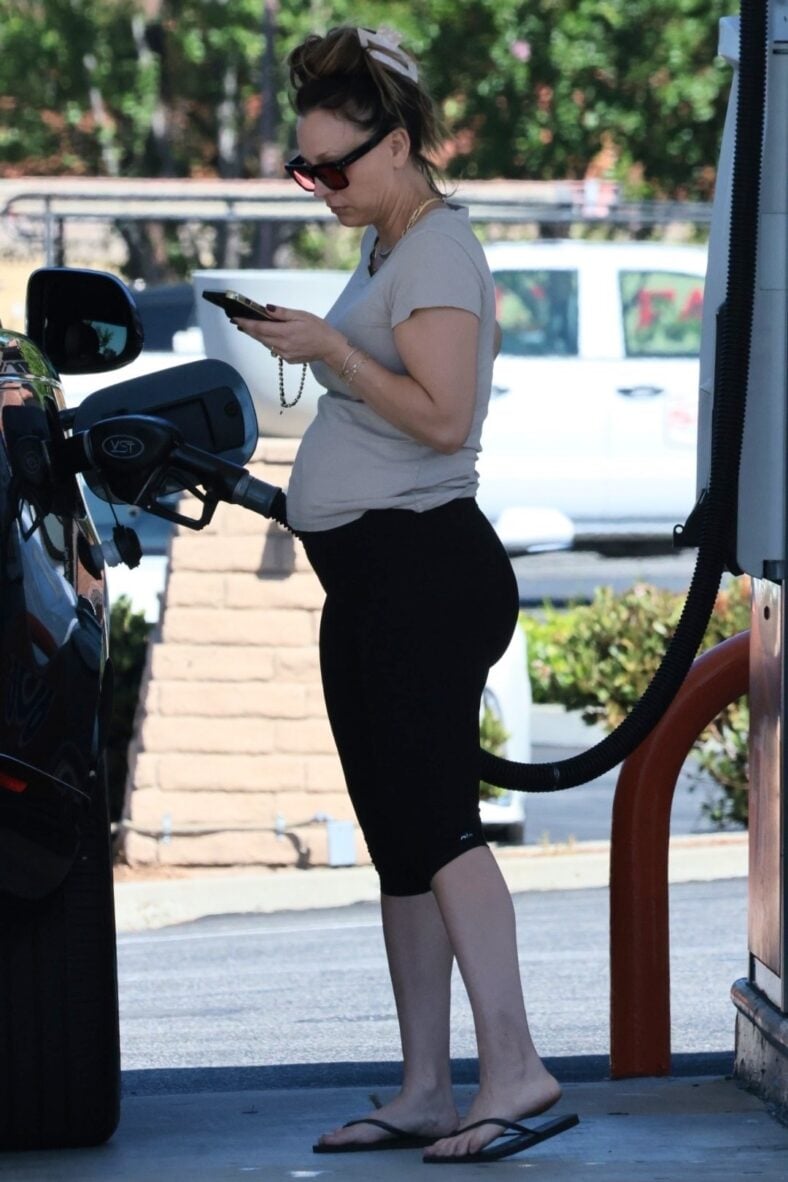 Kaley Cuoco pumping gas while on her cell phone