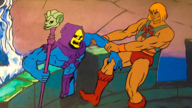 He-Man pulls Skeletor over a wall in 