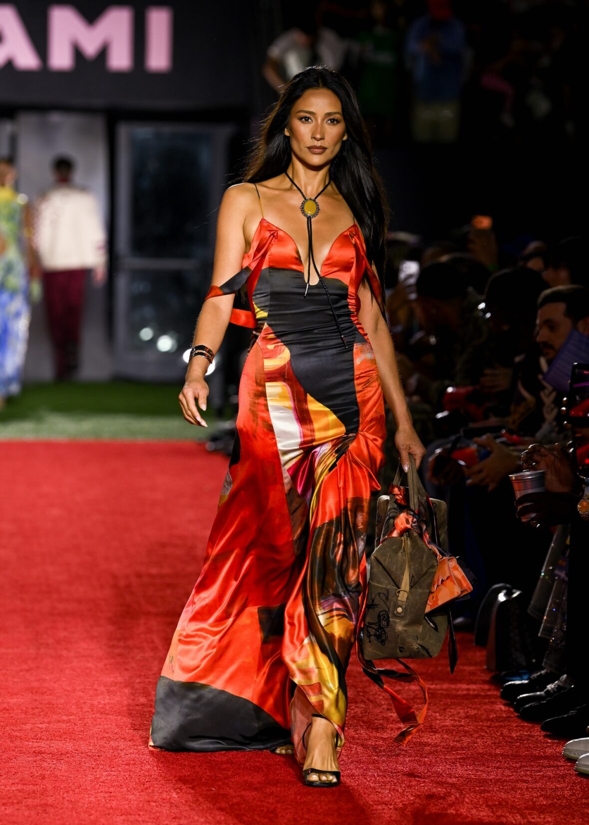 Shay Mitchell in an orange dress backstage