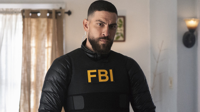 Omar Adom Zidan standing in a room wearing a black FBI vest over a black jacket