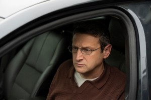 Tim Robinson in 'The Chair Company' sitting in a car and looking troubled.