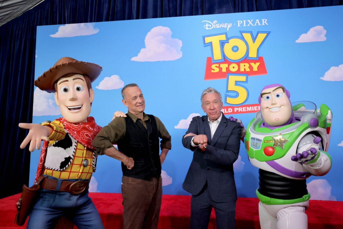 Tom Hanks and Tim Allen pose with Woody and Buzz at the Toy Story 5 premiere