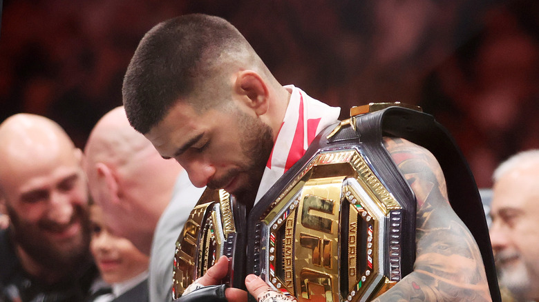 Ilia Topuria holding two titles at a UFC event