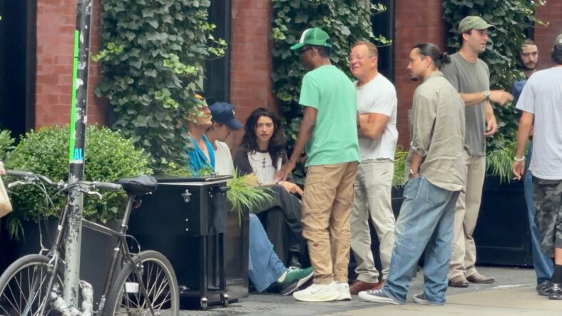 Austin Butler and Odessa A'Zion talking. Woody Harrelson and Chris Rock are next to them