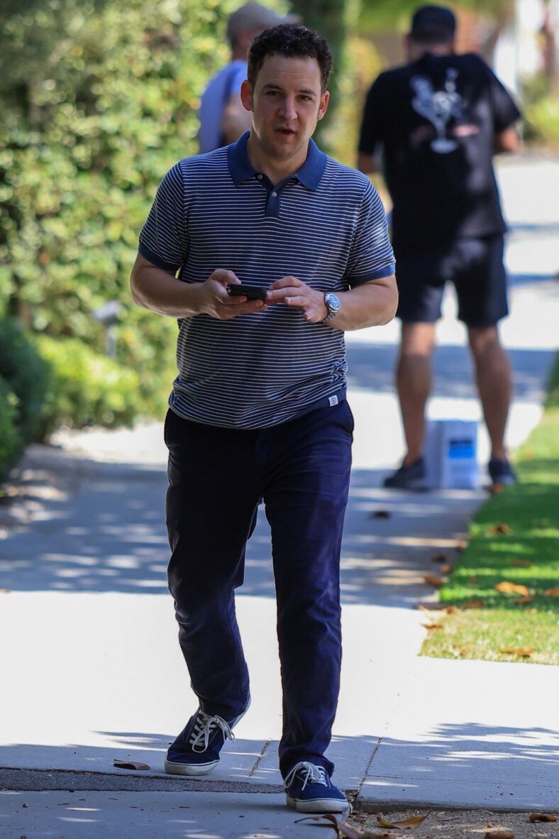 Ben Savage walking on a sidewalk in Santa Monica holding his cell phone and speaking