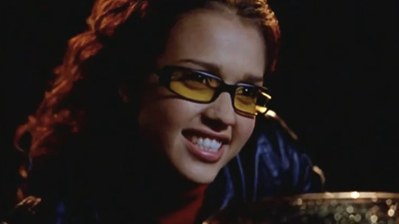 Jessica Alba as Max Guevara with shoulder-length dark hair and yellow-tinted glasses.