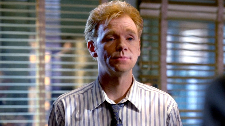 David Caruso wearing a white striped shirt and a blue tie on 