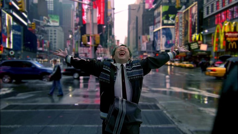 Hiro Nakamura with hands open wide, looking up on Times Street