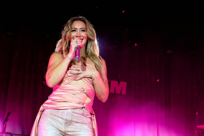 Hilary Duff smiles while performing on stage