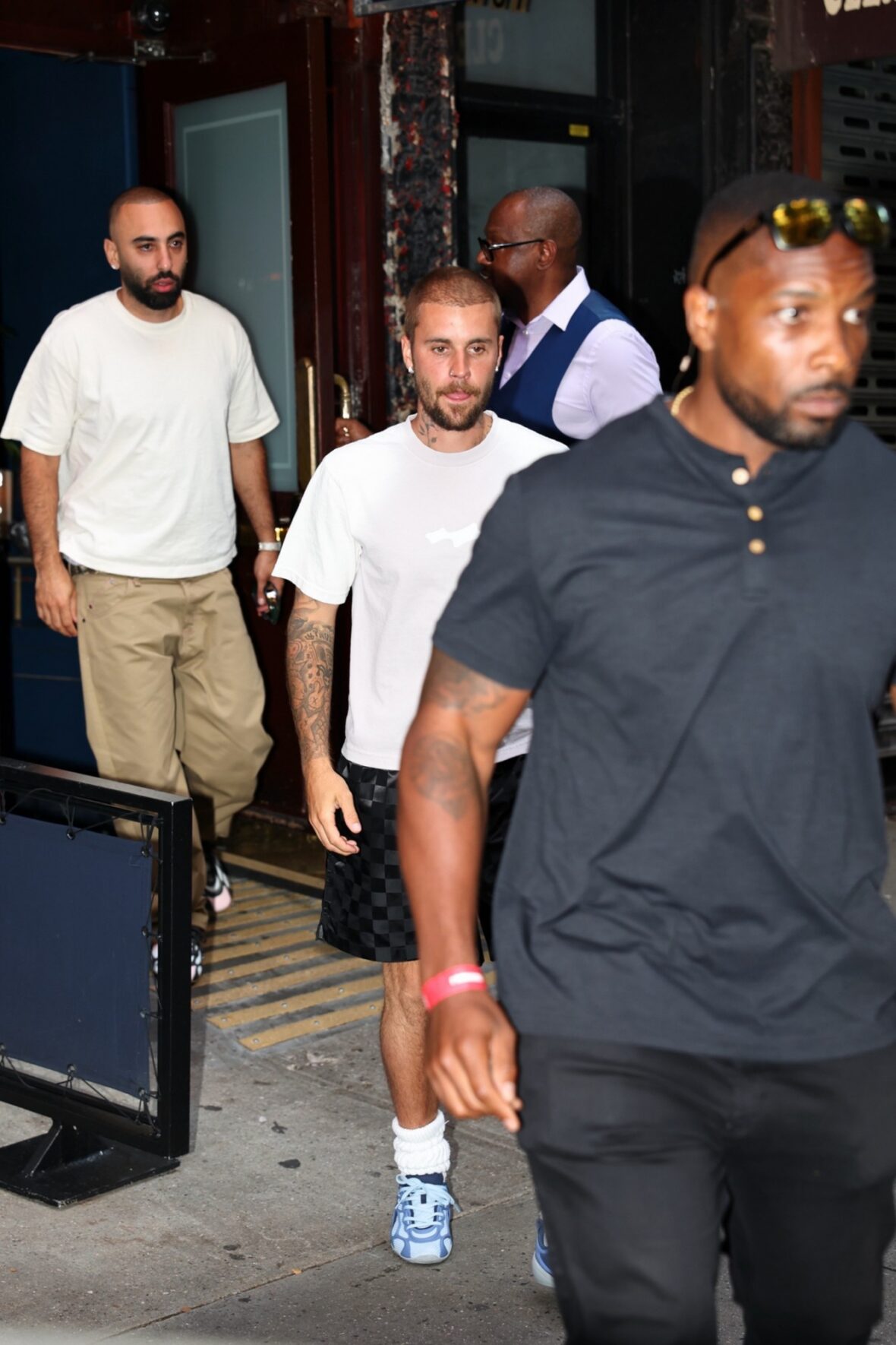 Justin Bieber in a white shirt, checkered pants, and sneakers in NYC.