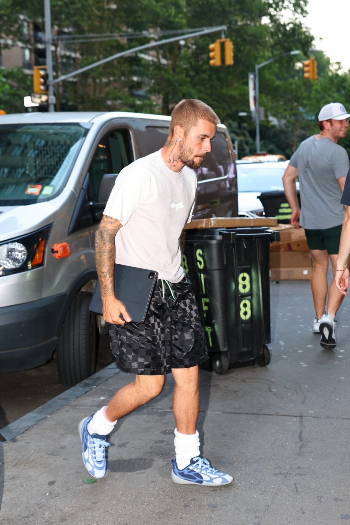 Justin Bieber in a white shirt, checkered pants, and sneakers in NYC.