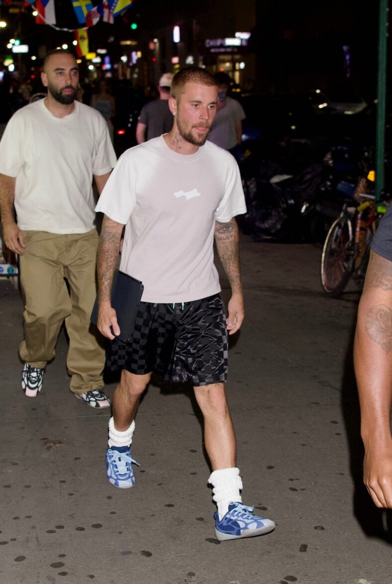 Justin Bieber in a white shirt, checkered pants, and sneakers in NYC.
