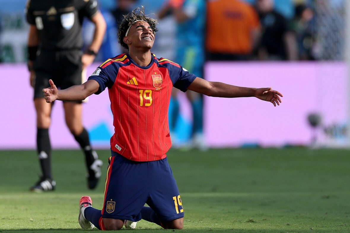 Lamine Yamal celebrating on the ground at MetLife stadium following Spain's World Cup win