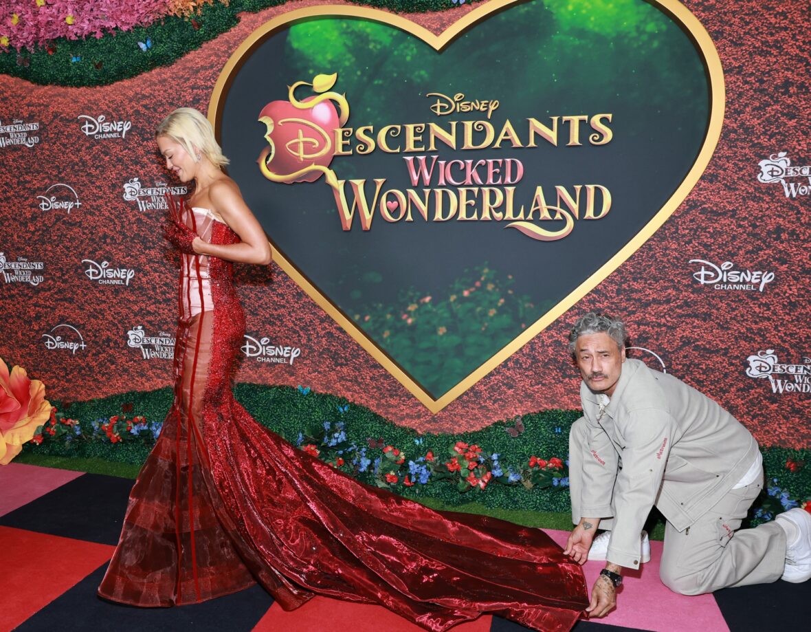 Taika Waititi helps Rita Ora with her dress at Descendants: Wicked Wonderland premiere