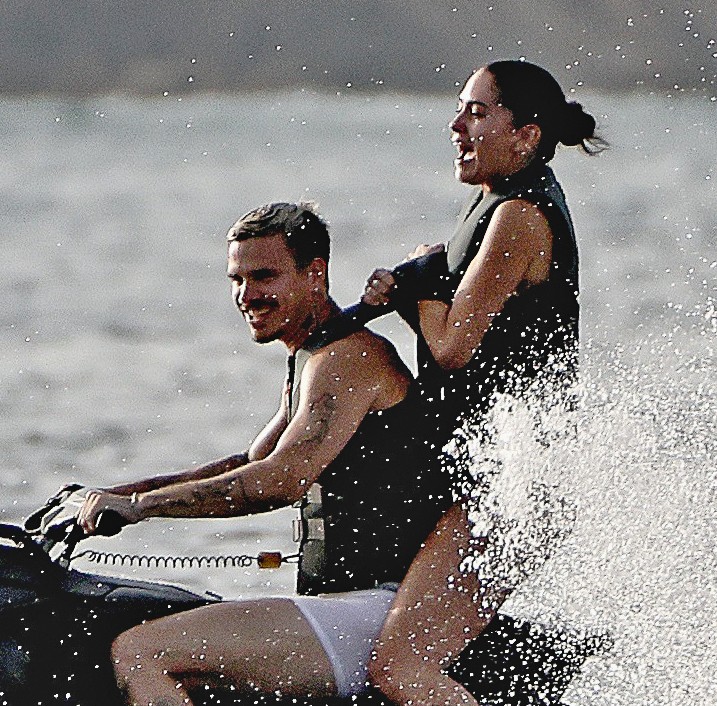 Romeo Beckham and Kim Turnbull on a jetski in the water