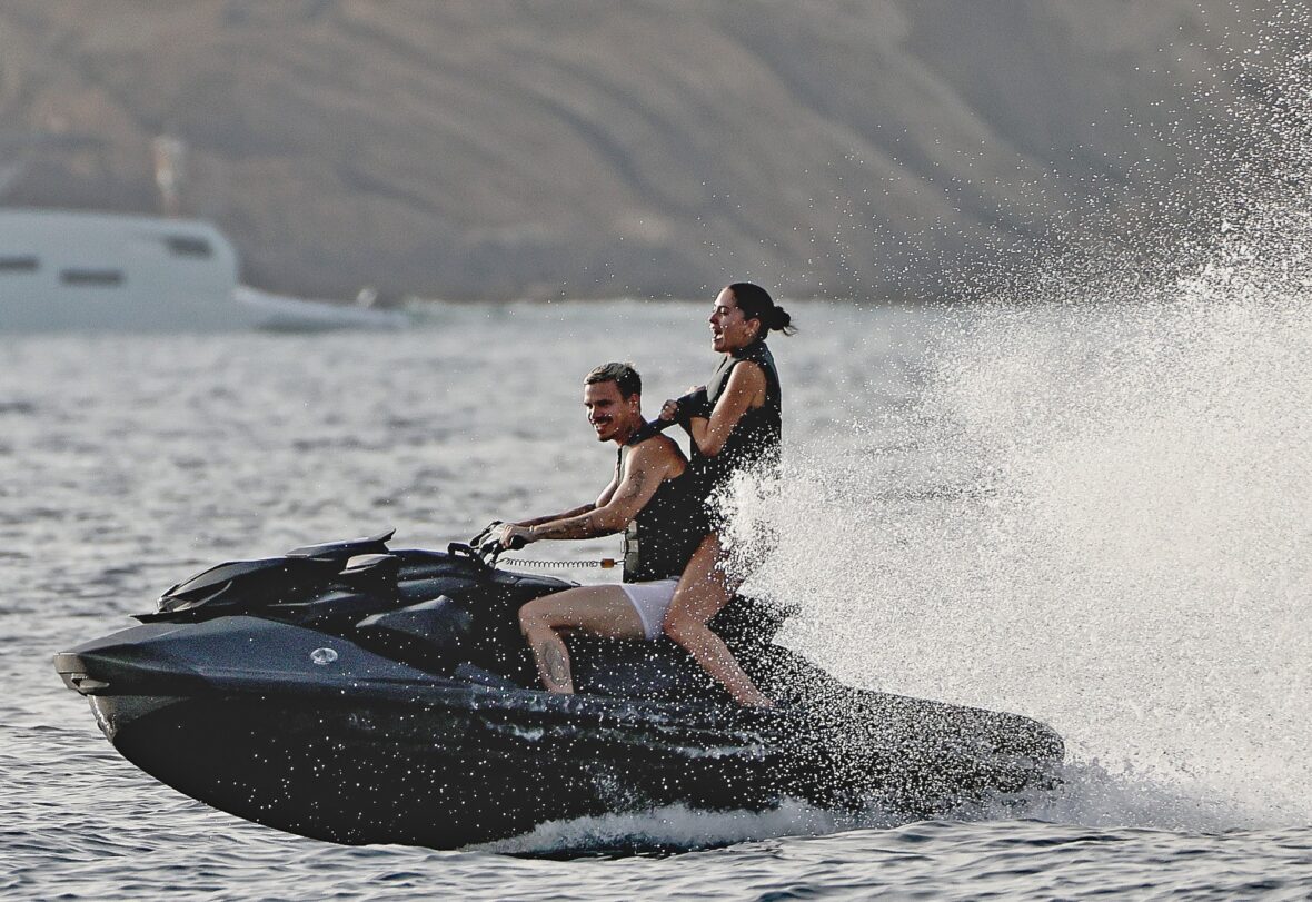 Romeo Beckham and Kim Turnbull on a jetski in the water