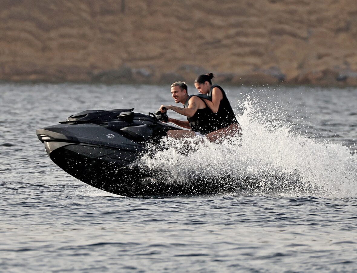 Romeo Beckham and Kim Turnbull on a jetski in the water