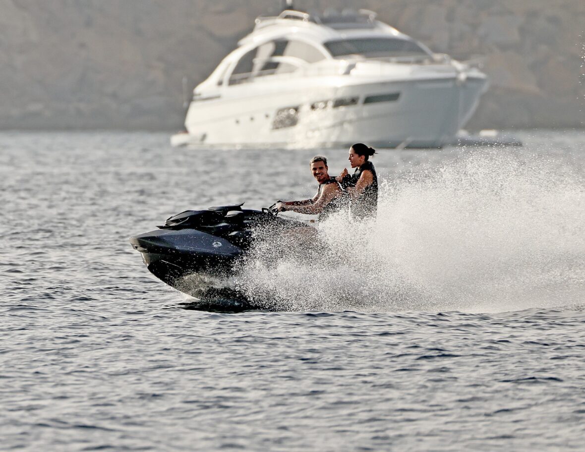 Romeo Beckham and Kim Turnbull on a jetski in the water
