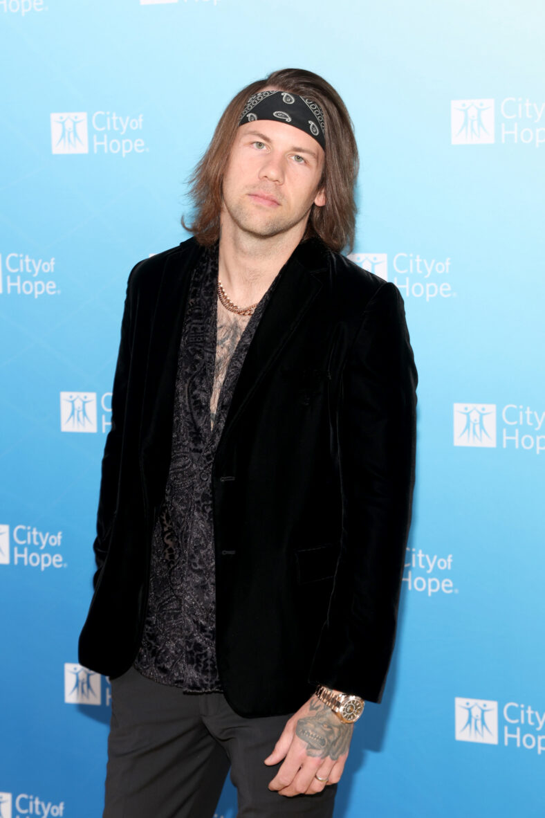 Caleb Shomo stock photo from a past appearance where he's posing solo on the red carpet with a straight face and bandanna.