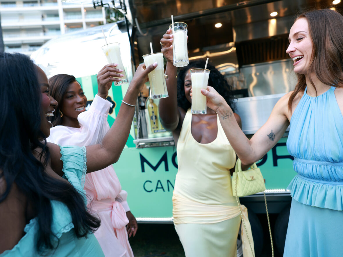 Sophie Turner wears chiffon wrap top and skirt while posing with guests at St. Germain's pop-up in Cannes