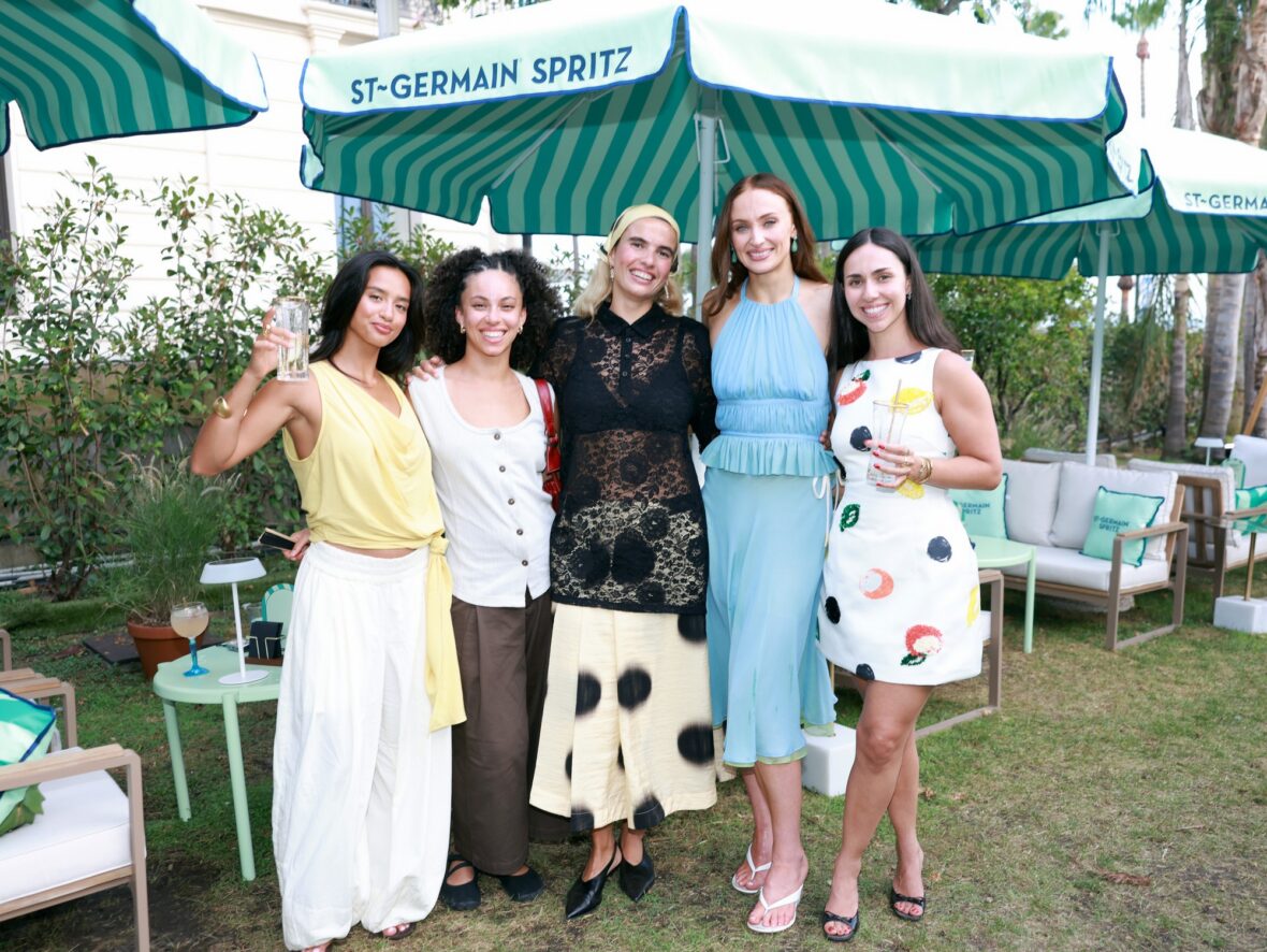 Sophie Turner wears chiffon wrap top and skirt while posing with guests at St. Germain's pop-up in Cannes