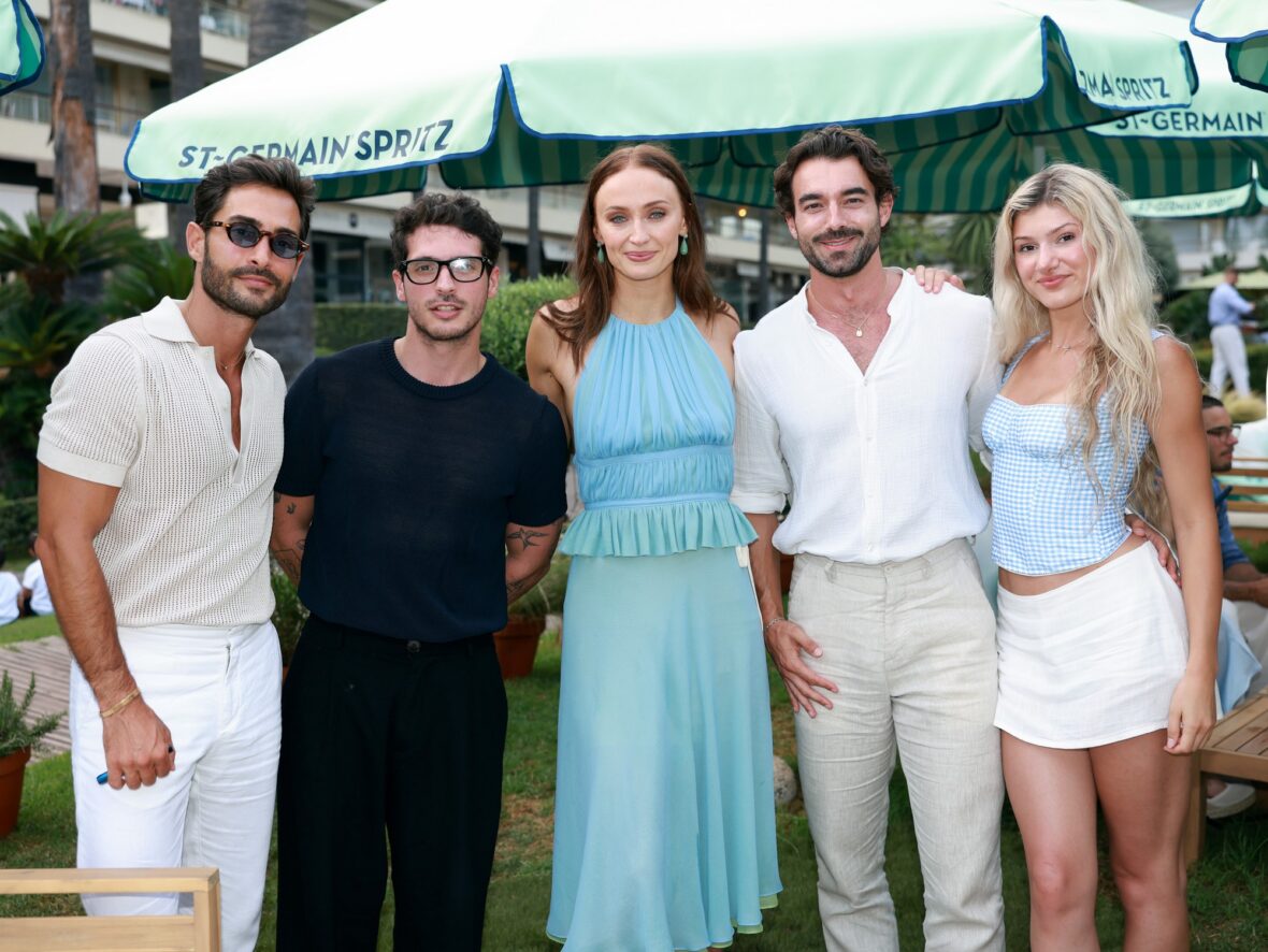 Sophie Turner wears chiffon wrap top and skirt while posing with guests at St. Germain's pop-up in Cannes