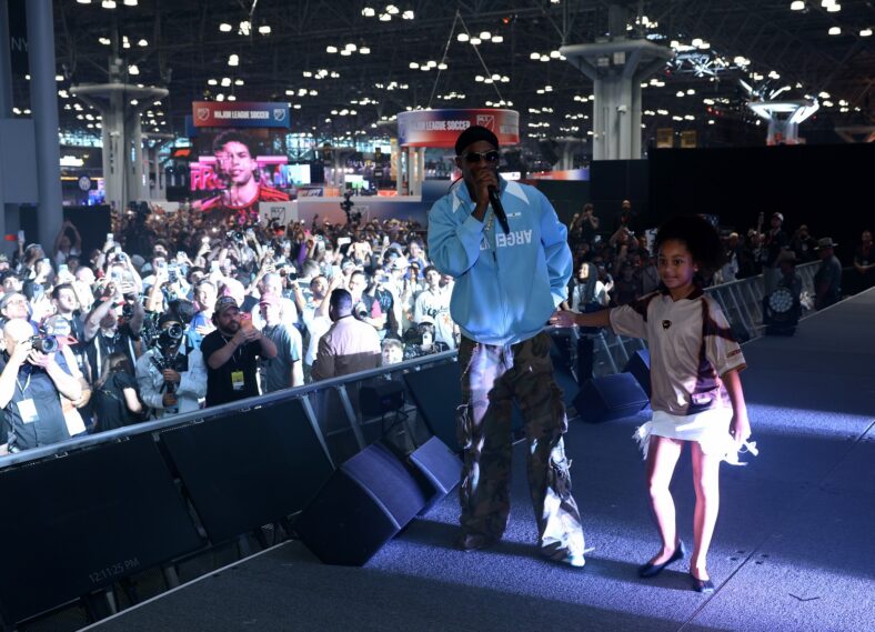 Travis Scott performs on stage at Fanatics Fest with daughter Stormi