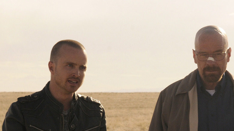 Tuco Salamanca (Raymond Cruz) stands right next to a kneeling Jimmy McGill (Bob Odenkirk) in 